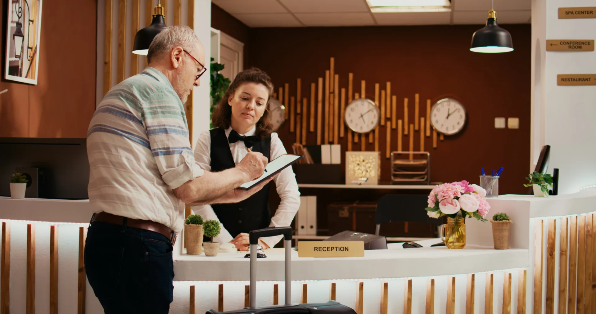 Recepcionista de hotel atendiendo a un huésped en el check in, ejemplo del equilibrio entre atención humana y digitalización en el sector turístico.