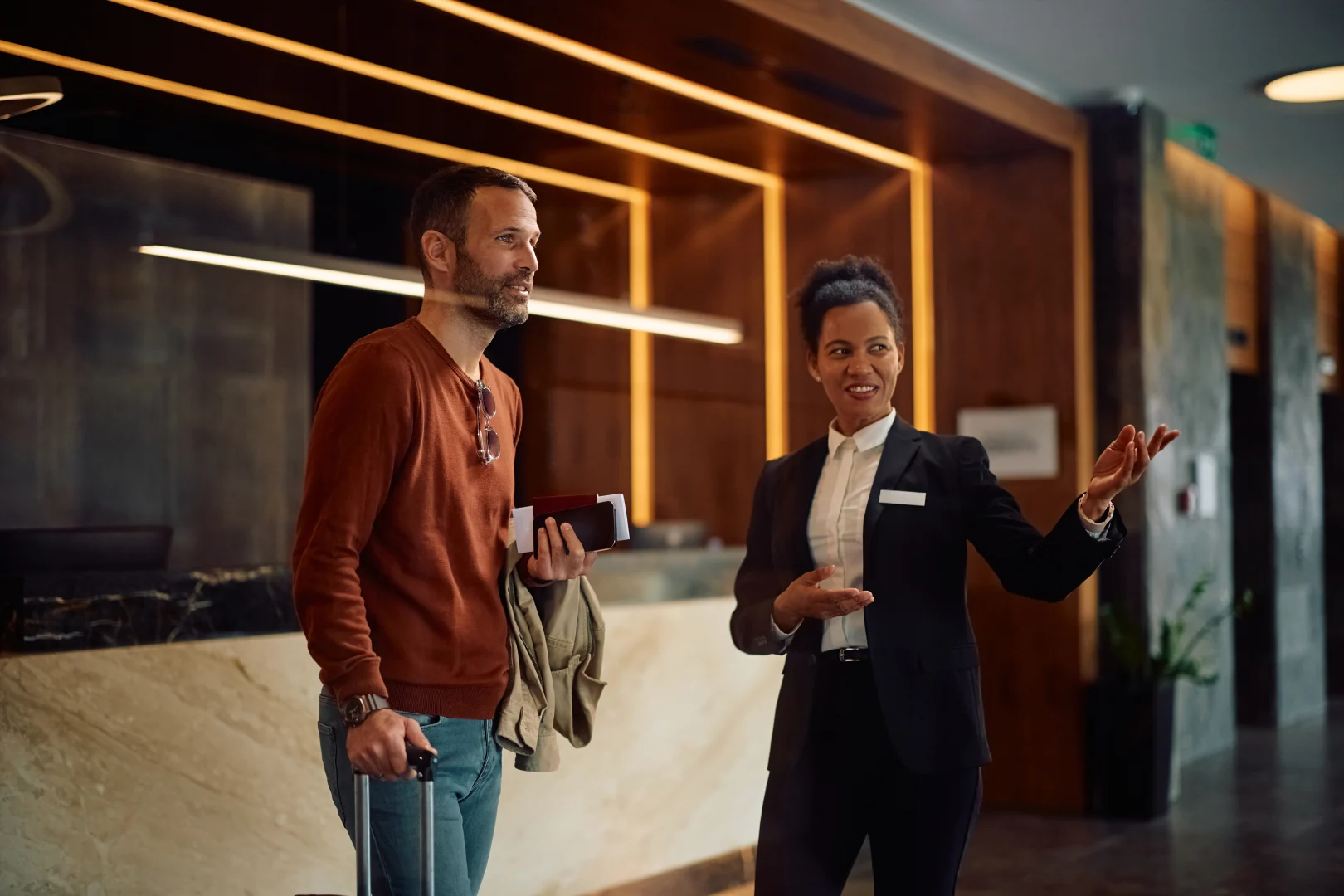 Hotel receptionist attending to a guest with a professional and friendly attitude.