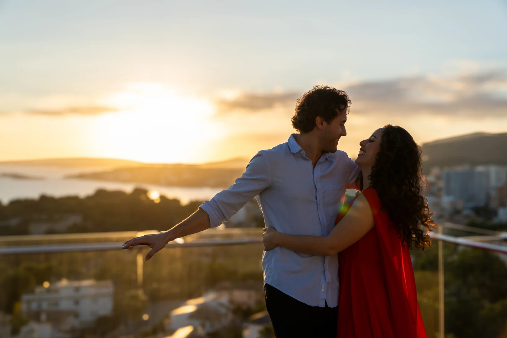 Couple enjoying a romantic sunset experience on a hotel terrace with panoramic views.