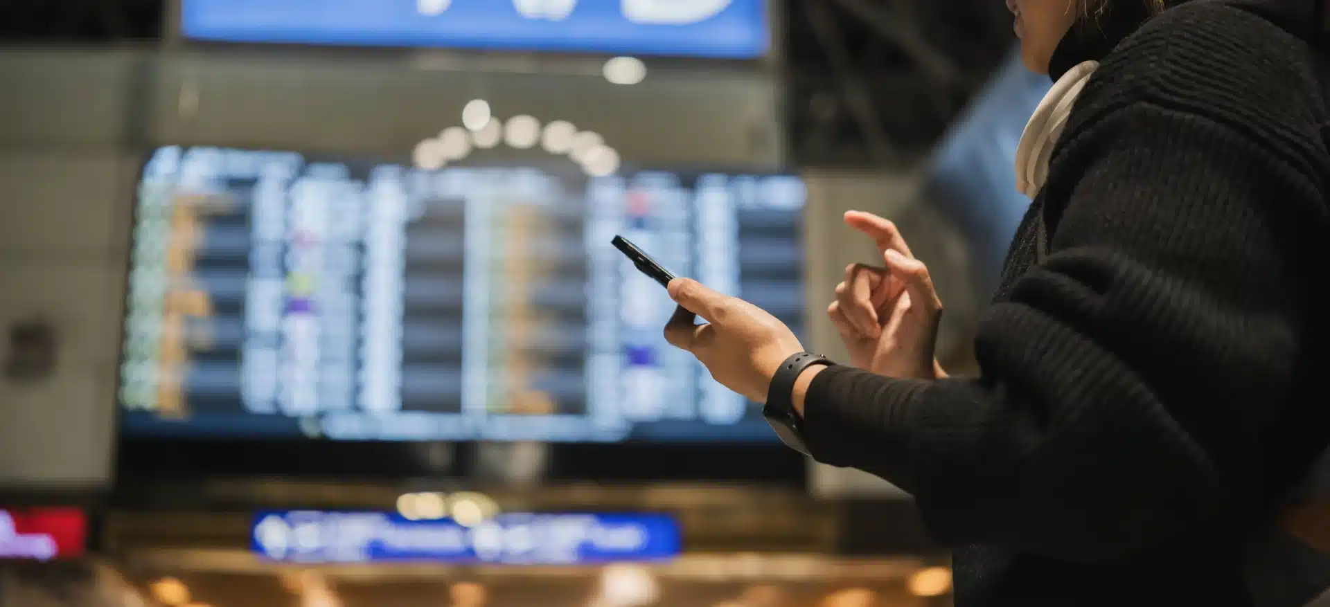 Persona consultando redes sociales en el aeropuerto antes de elegir destino de viaje