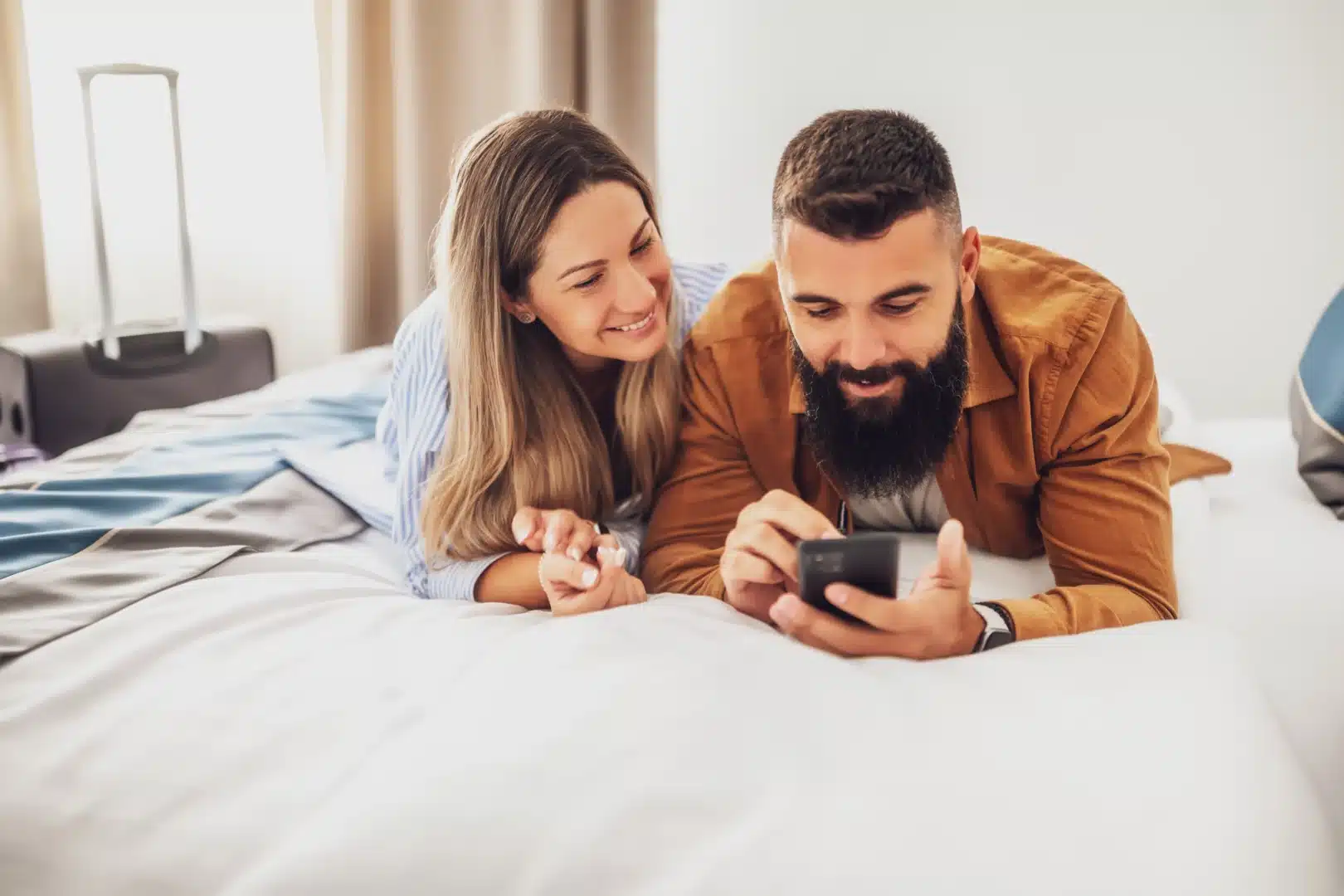 Pareja comparando hoteles en el móvil tras descubrir destinos en redes sociales