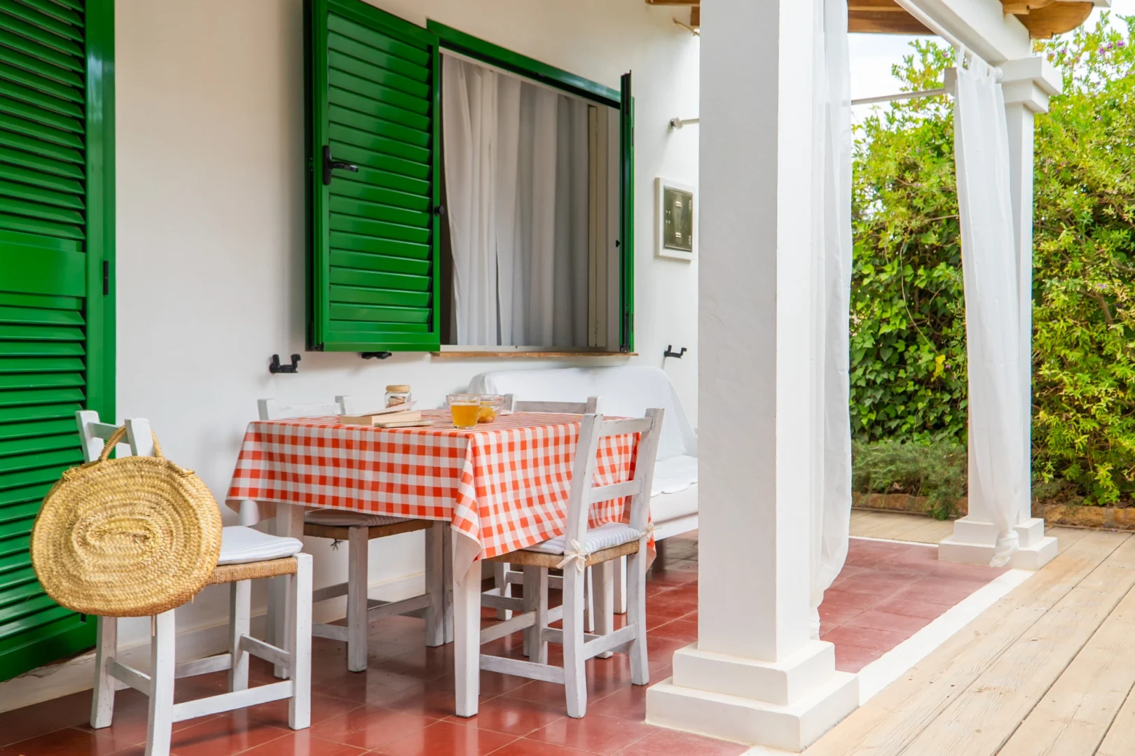 Typical Formentera terrace with checkered table and green shutters, symbol of the local charm that Formentera Break transmits.